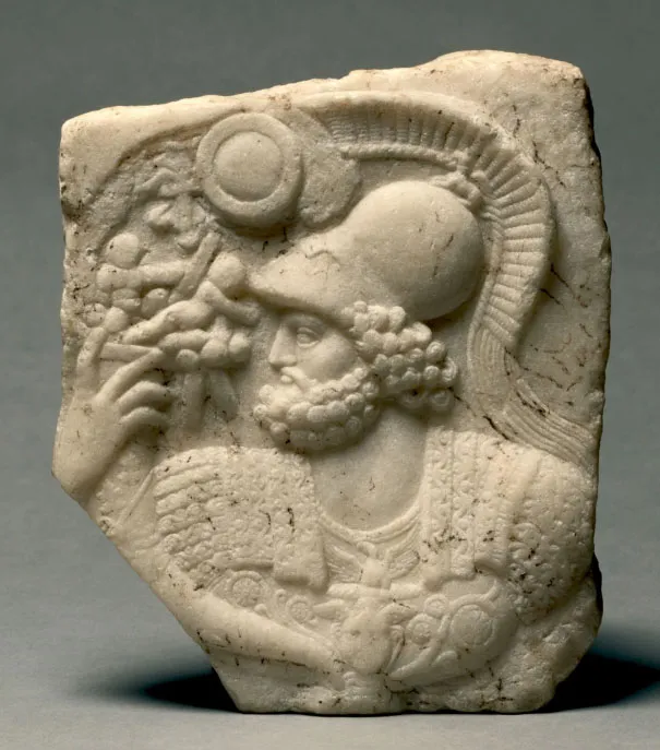 Broken marble relief panel showing a bearded figure in profile wearing a crested helmet and a decorated cuirass.