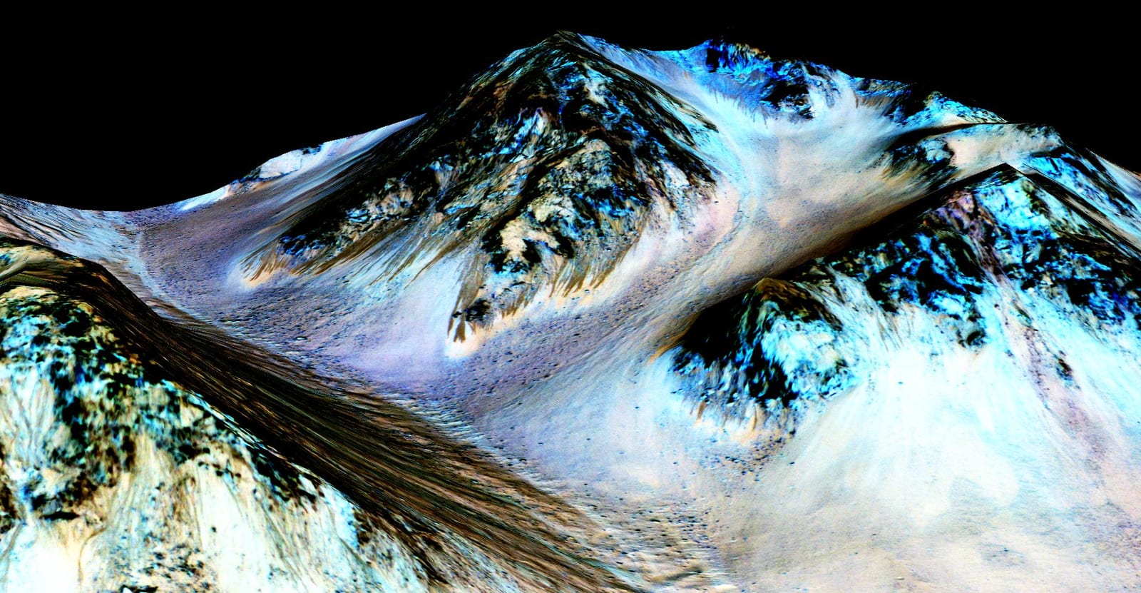 A false-colour orbital view of a steep crater slope scored by many narrow dark streaks running downhill.